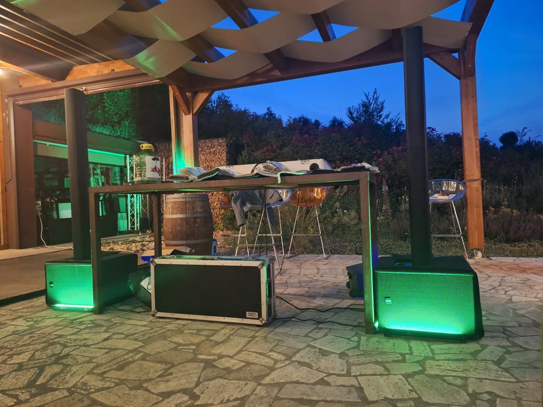 Postazione DJ con impianto audio e illuminazione verde